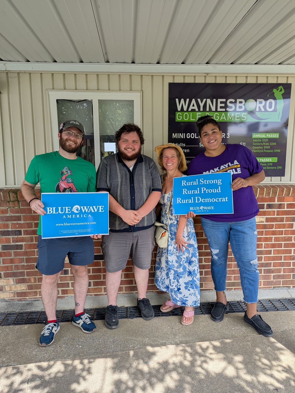 Blue Wave America volunteers holding Rural Strong, Rural Proud, Rural Democrat signs.